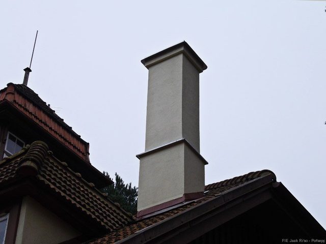 Heleda krohviga viimistletud korstnapits katuse kohal