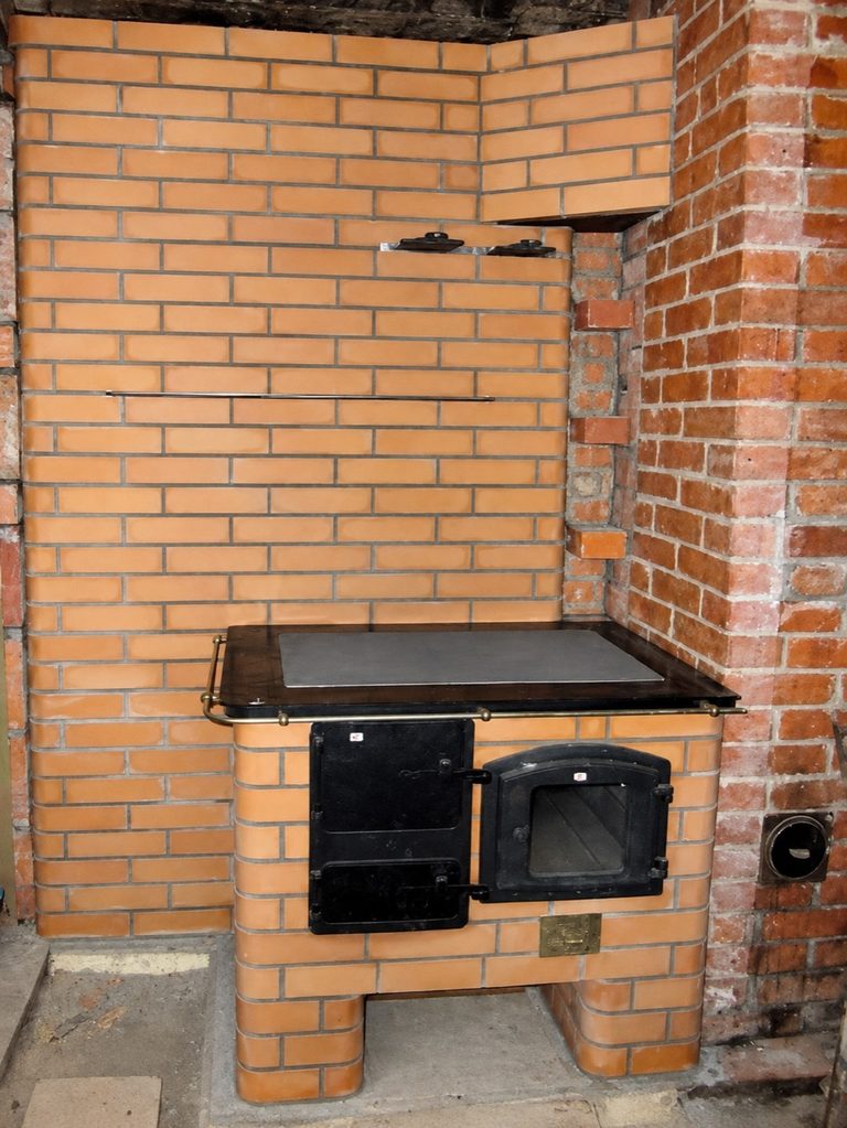 Tellispliit musta pliidiplaadi ja praeahjuga soojamüüri ees